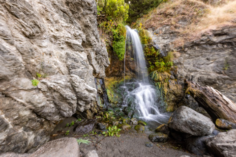Waterfall running onto beach on Oregon Coast. Gold Beach, Oregon, United States