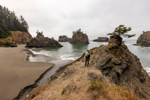 Female hiker on beach along Oregon Coast. Gold Beach, Oregon, United States