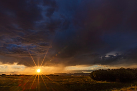 Heavy rain clouds and sun setting above landscape. Bellevue, Idaho, United States