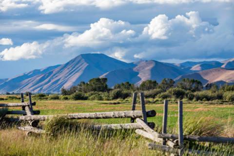 Fence in field with hills in background. Bellevue, Idaho, United States