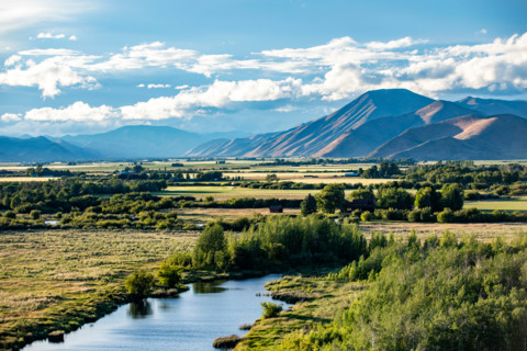 Silver Creek crossing field with hills in background. Bellevue, Idaho, United States