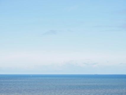 Clear light blue sky above calm sea. Port Douglas, Queensland, Australia
