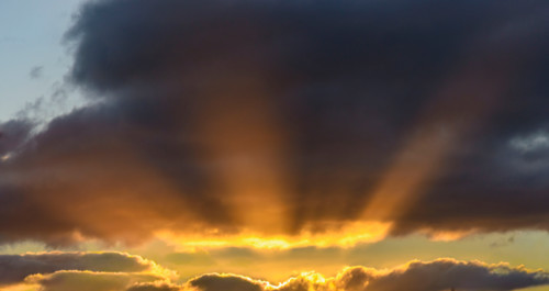 Sunbeams break out from sunset cloud formation. Leura, New South Wales, Australia