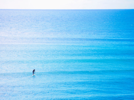 Distant paddleboarder in vast blue sea. Sunshine Coast, Queensland, Australia