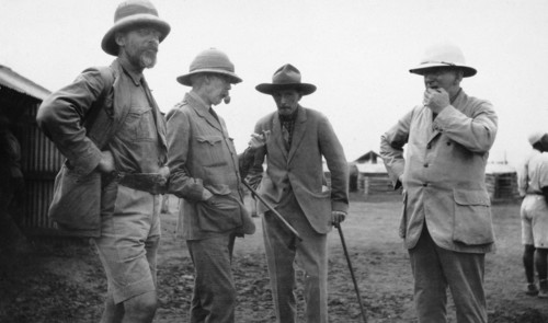 European settlers, Kenya. Exterior shot of four mature European men engrossed in conversation. All
