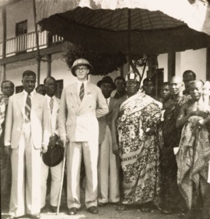 Empire Day in Aburi, 1950. A European colonial officer stands beneath a shady parasol with an Agona
