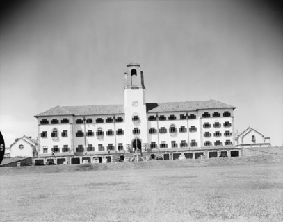 Clock tower at Makerere Hill. A large building with numerous windows and a prominent clock tower is
