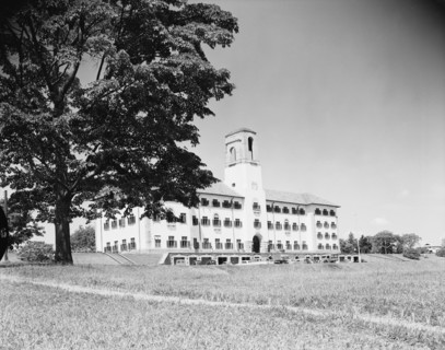 Clock tower at Makerere Hill. A large building with numerous windows and a prominent clock tower is