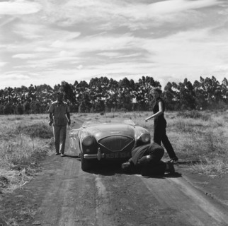 Fixing 55. Driver Morland and team check over their Austin-Healey racing car in the retries of race