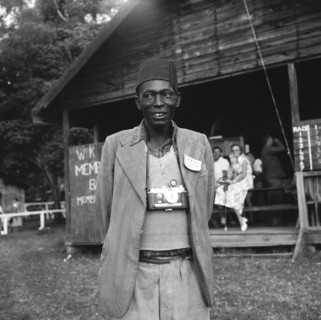 Smile for the camera. An African man wearing a jacket and a fez hat smiles for the camera at the