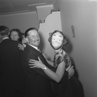 Monkeying around. Couples dancing at the Archer's New Year party. The woman in the foreground wears