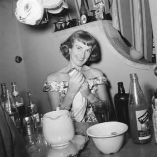 Drying up. A cheerful woman dries a glass at the Archer's New Year party. The table in front of her