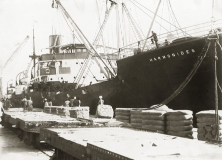 Bogies and SS Harmonides. Cranes onboard SS Harmonides prepare to lower a power bogie onto the