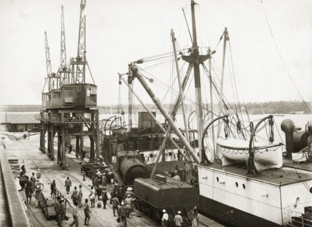Unloading a train from SS Harmonides. Overhead view of the cranes onboard SS Harmonides lowering a