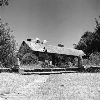 Name painting. A man on a ladder paints the name 'GABB' in large letters on the pitched roof of a