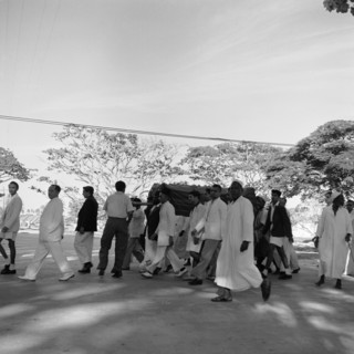 Zanzibar funeral. An all male funeral procession dressed predominantly in white, makes its way
