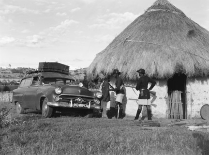 Askaris and Ford. A group of armed askaris direct a man towards a Ford car parked outside a