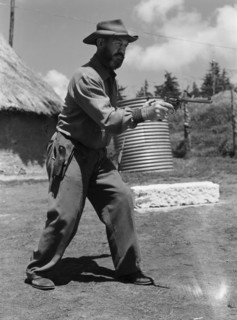 Davo' Davidson takes aim. Davo' Davidson aims a revolver. Kenya, 22 May 1953. Kenya, Eastern