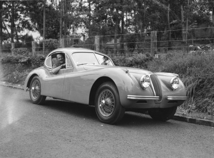 Peter Knight's Coupe Jaguar. Peter Knight smiles for the camera from the window of his Coupe Jaguar
