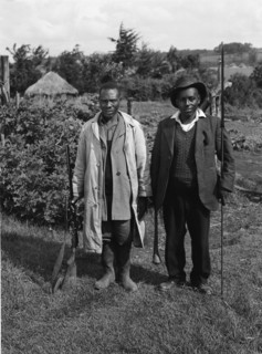 Uplands home guards. Two home guards, one armed with a rifle, the other with a club and spear. The