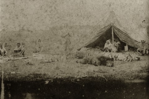 Trophies at a hunting camp. A British hunter stands proudly over the day's hunting spoils which