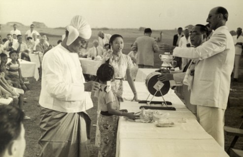 Raffle for six bottles of whisky. The President of the Rangoon Golf Club spins a drum full of