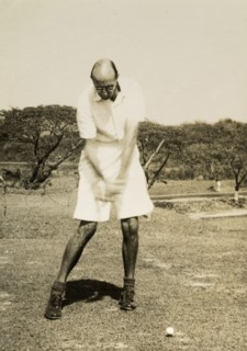 Stiff left side'. R.B. Groves, a Captain of the Rangoon Golf Club, takes a swing at the ball on the