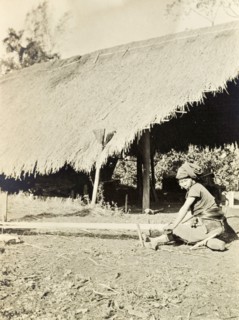 A Kachin woman weaving. A Kachin women in traditional dress weaves yarn by hand on a horizontal