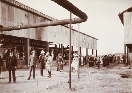 Tour of an industrial factory. A group of smartly dressed European men and women take a tour of an