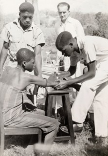 An African medic injects a patient. An African medic gives an injection to a female patient, while
