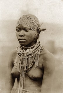 Kenyan woman in beaded headdress. Half-length portrait of a semi-naked woman wearing a beaded