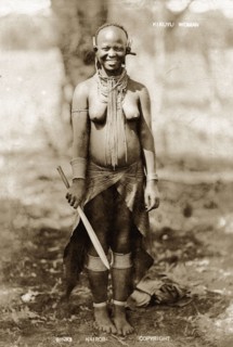 Kikuyu woman smiling. Full-length portrait of a smiling Kikuyu woman wearing neck, ear, arm and leg