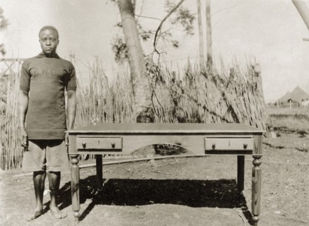 Cabinetmaker with desk. A Public Works Department employee, identified in the the caption as