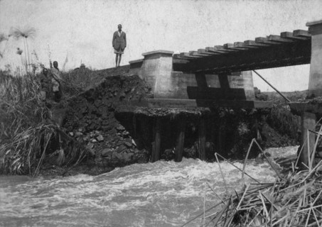 Bridge wash-out. Water rushes underneath a damaged railway bridge on the Thika-Nairobi branch