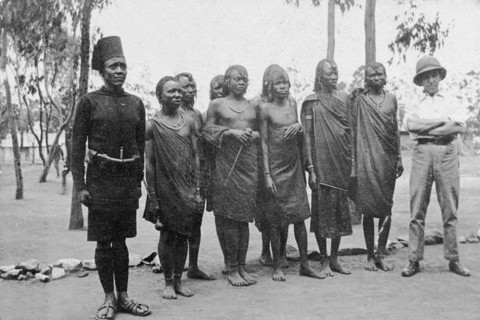 Raw recruits. A European officer and an African soldier stand either side of a small group of