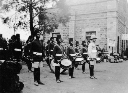 The band of 2/2nd King's African Rifles. A European officer stands at the front of several rows of