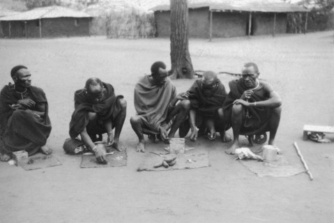Snuff sellers at Machakos. Five snuff sellers squat on the road, their wares spread out on small