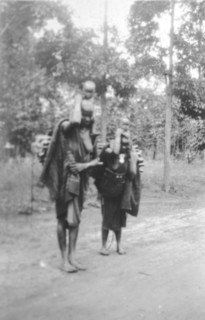 Kamba women with children. Two barefooted Kamba women in traditional dress carry small children on