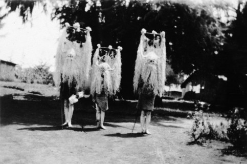 Nandi youths wearing circumcision masks. Three Nandi youths wear tall, elaborate grass headdresses