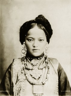 Bhutia woman. Portrait of a finely dressed young Bhutia woman in traditional costume. Her hair is