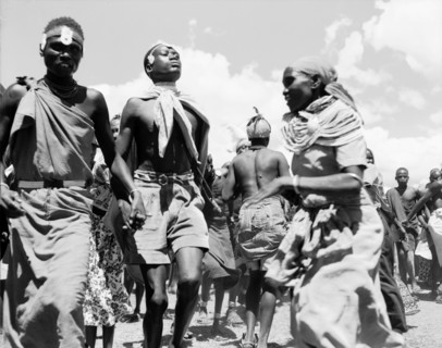Turkana dancers. Two Turkana men hold hands in the midst of a traditional dance involving both men