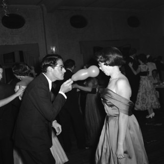 Balloon antics. A straight-faced man brandishes a party balloon in the face of his surprised dance