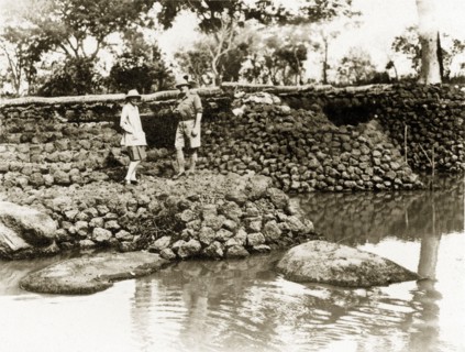 River bridge. Two European men stand on a stone bridge built in January 1928 by Captain Burges