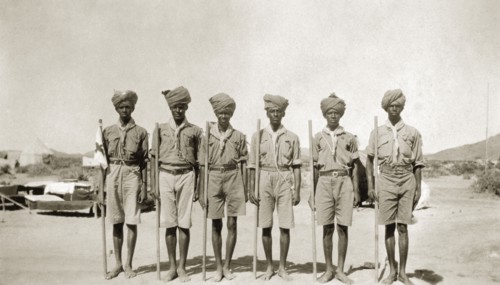 African scout group. A group of African men at a scout camp. Each carries a stick and wears a