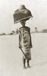 East African fisherwoman. An east African fisherwoman balances a large basket and fishing net on