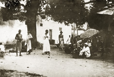 Mombasan street scene. A group of people mill about on a street corner in the centre of town.