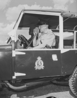Kenyan police jeep. A uniformed policeman sits inside a police jeep operating a radio receiver