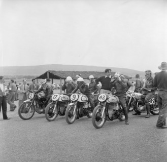 Nakuru motorcycle race. A group of riders sit astride their numbered motorcycles, adjusting their