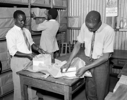 Packing books for dispatch. Promotional shot for the East African Literature Bureau. Three African