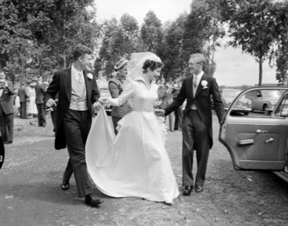 Newlywed runaways. The best man opens the door for the newlywed Patterson couple as they dash